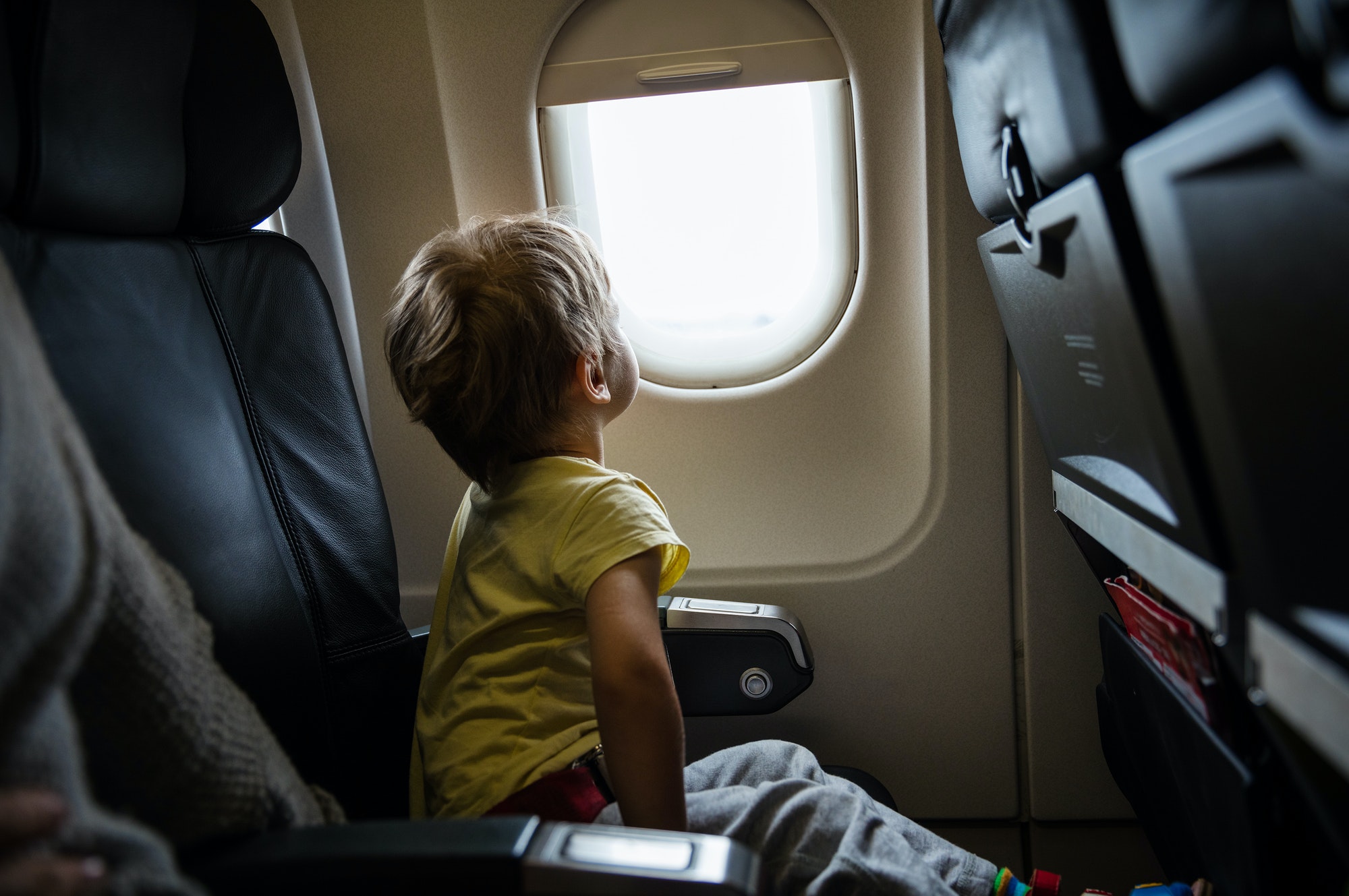 Little boy looking out of window in airplane