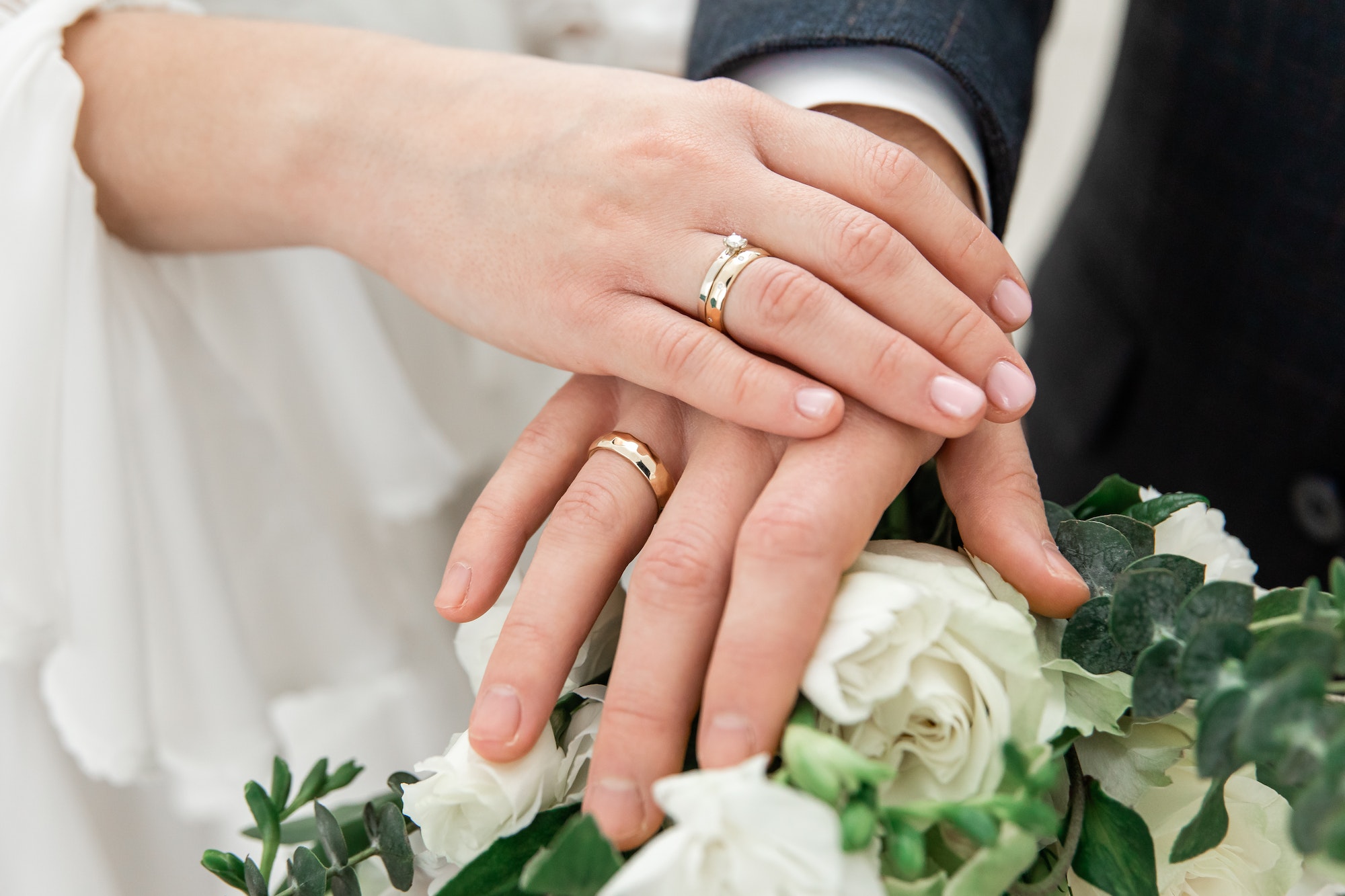 Hands of the bride and groom with wedding rings on a bouquet. The wedding ceremony. Love. Wedding ri