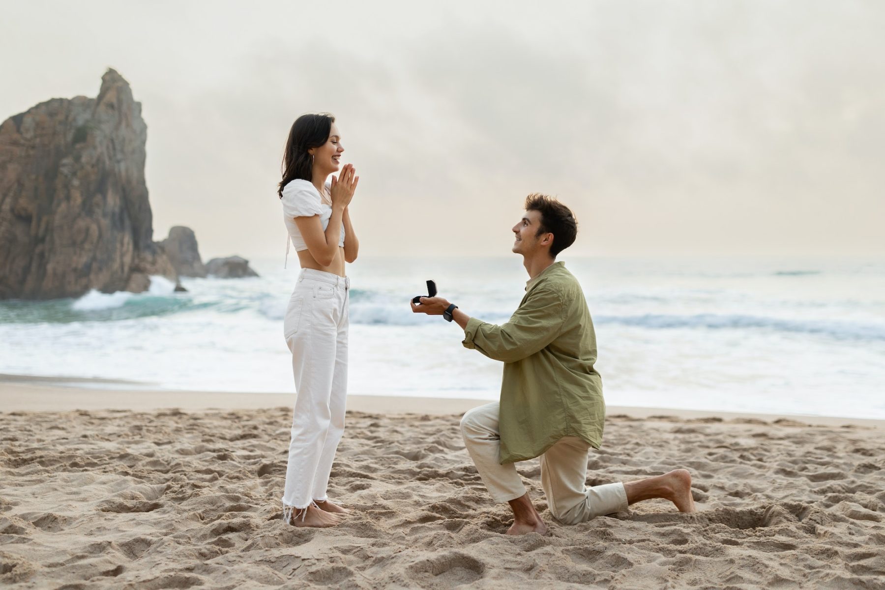 Romantic proposal on the seashore. Loving young man with engagement ring making proposal to happy