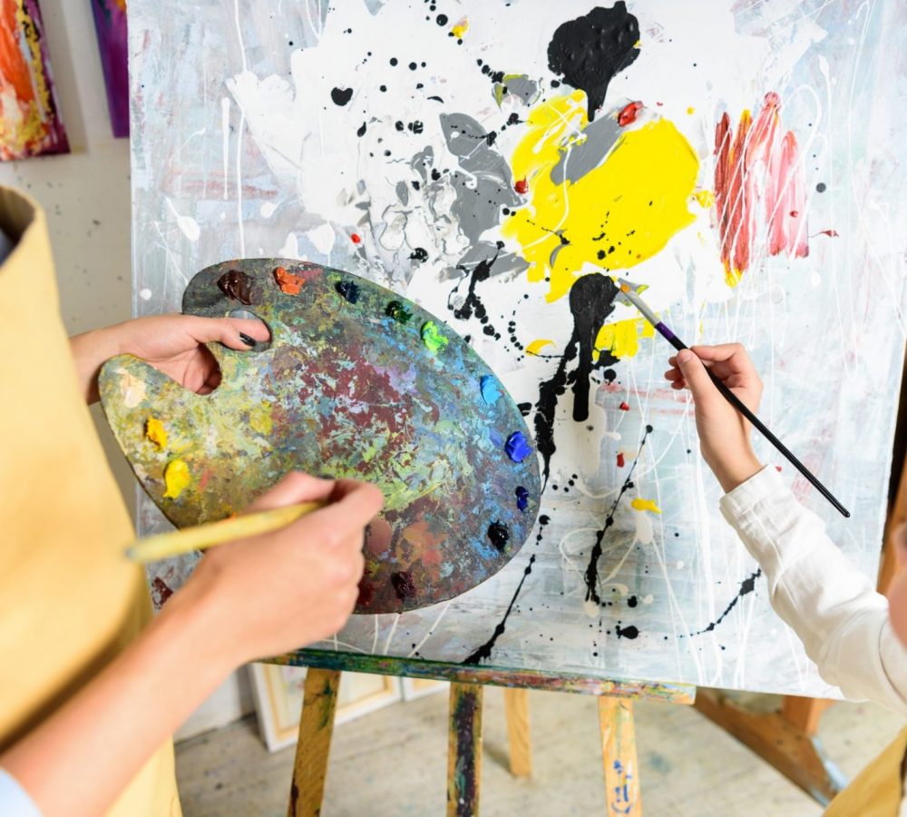 cropped image of pupil painting on lesson in workshop of art school