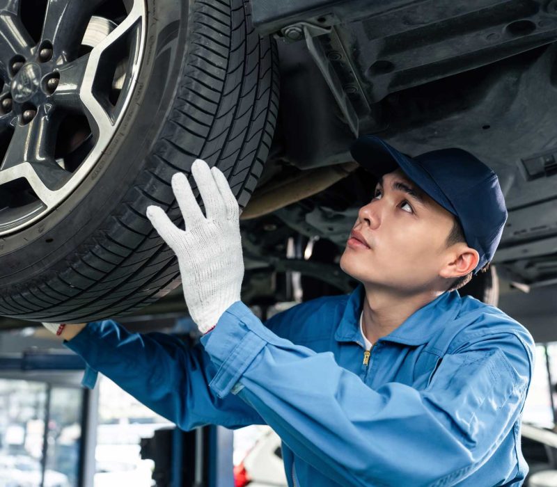 asian-automotive-mechanic-repairman-look-under-car-N3DC7P3