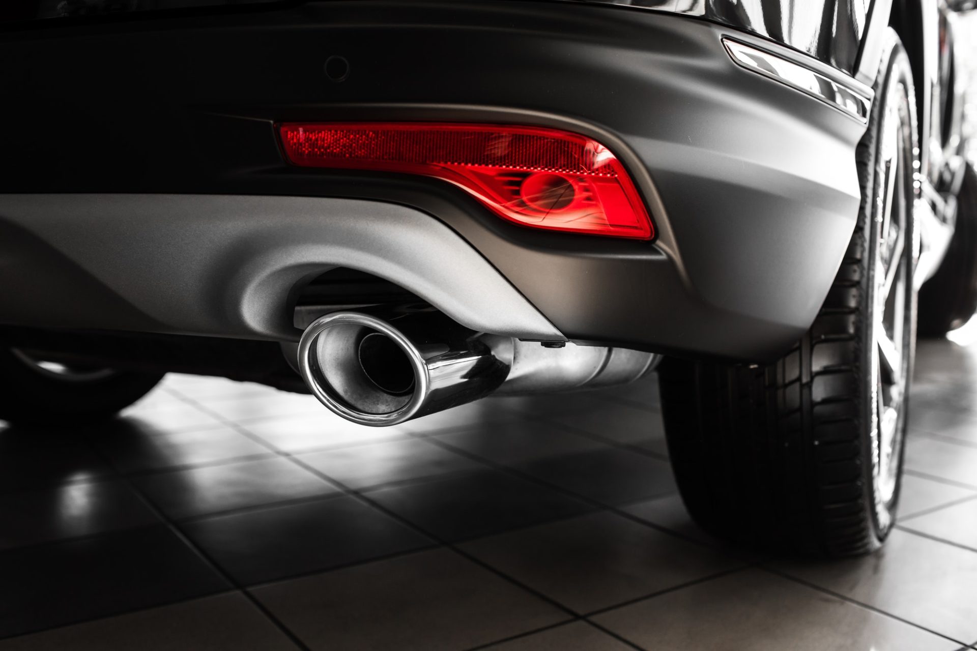 luxury car. Tailpipe chromed made of stainless steel on powerful sport car bumper.