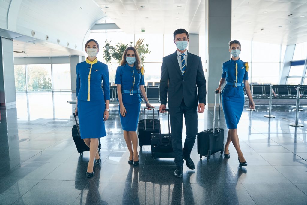 Cabin crew with trolley bags walking ahead