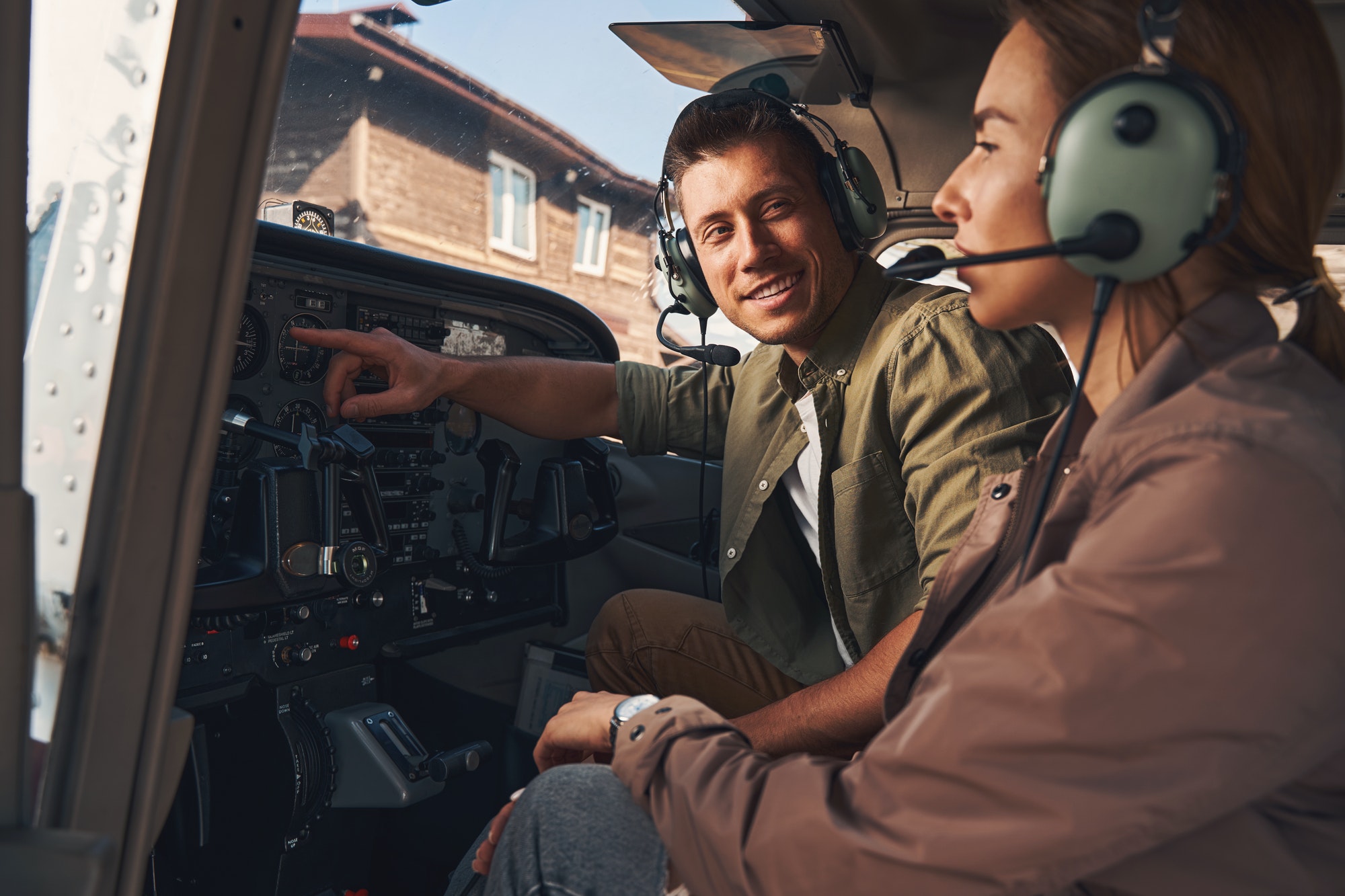 Cheerful young man giving flight lesson to woman