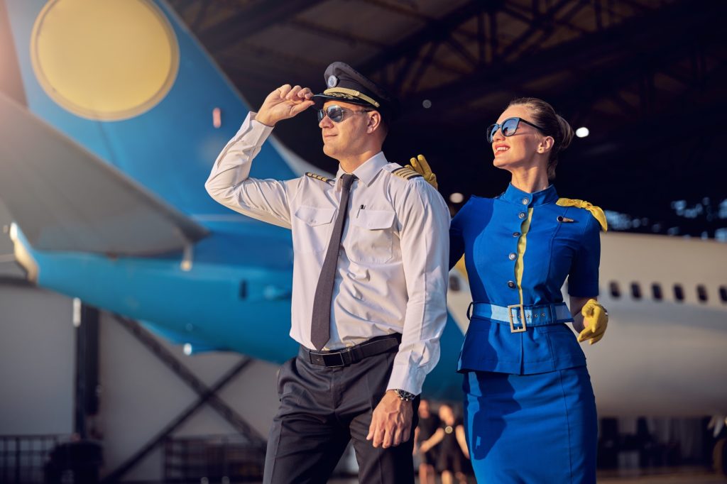 Handsome man and woman having fun in the aviation hangar