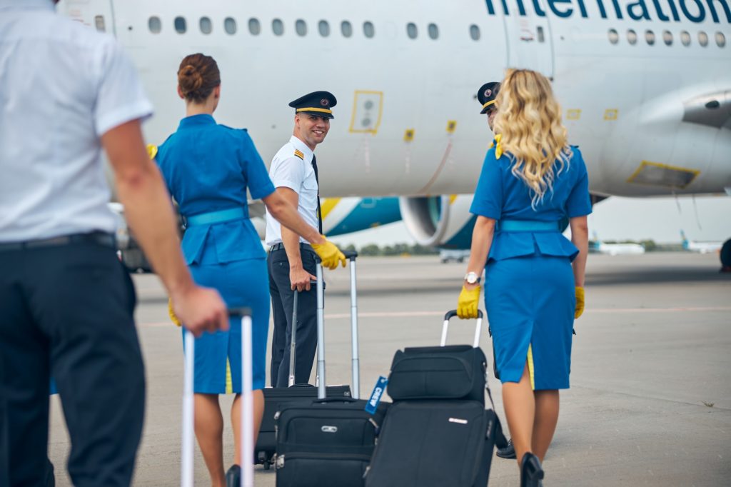Pilots and stewardesses carrying travel bags at airport