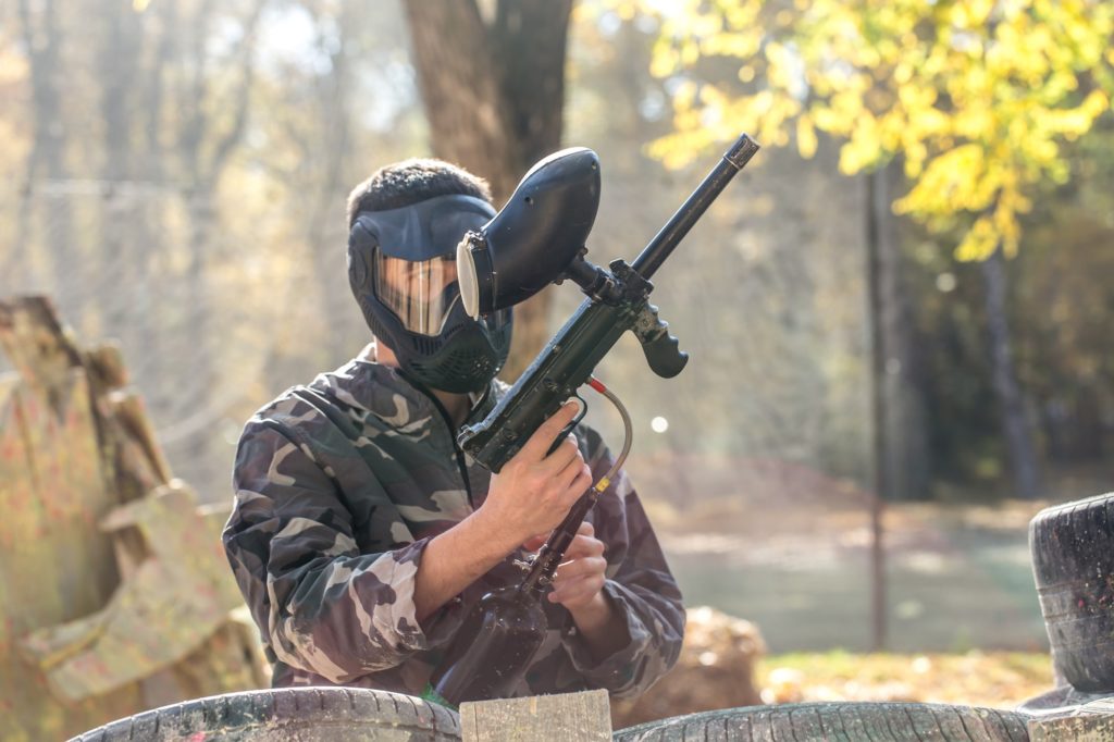 A man with a gun playing paintball.