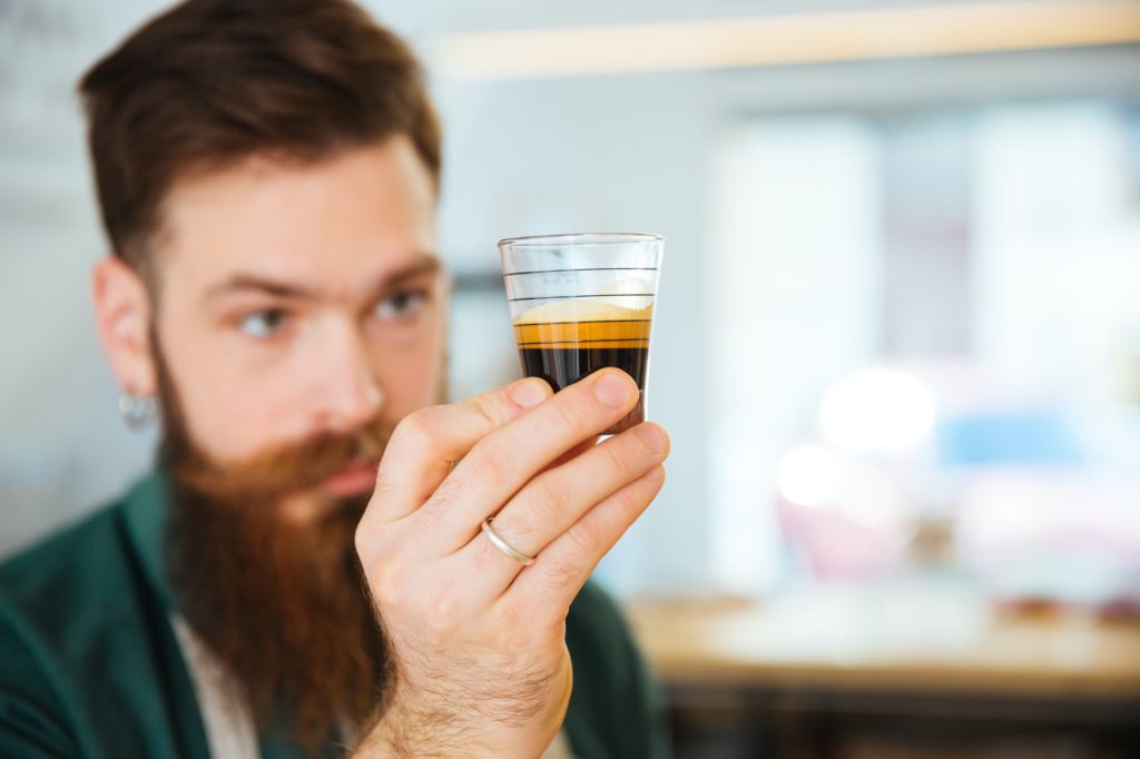 Barista holding glass with coffee