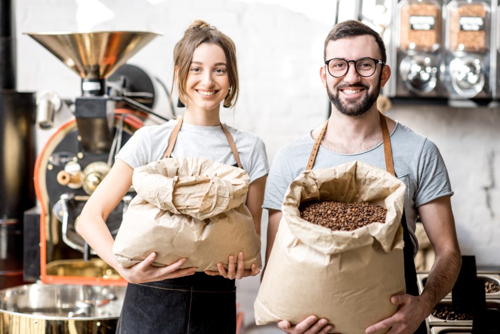 Portrait of baristas with coffee beans