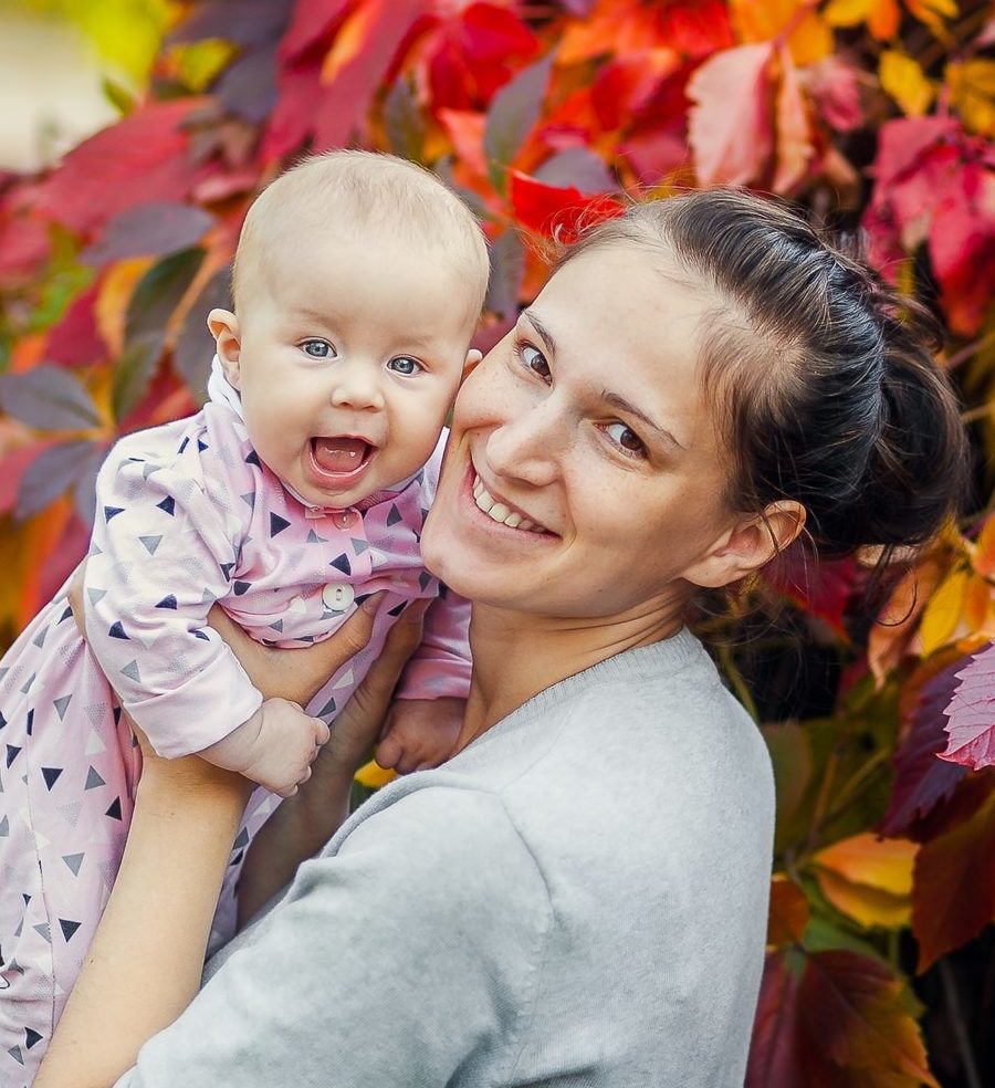 happy mom with baby in her arms in autumn landscape