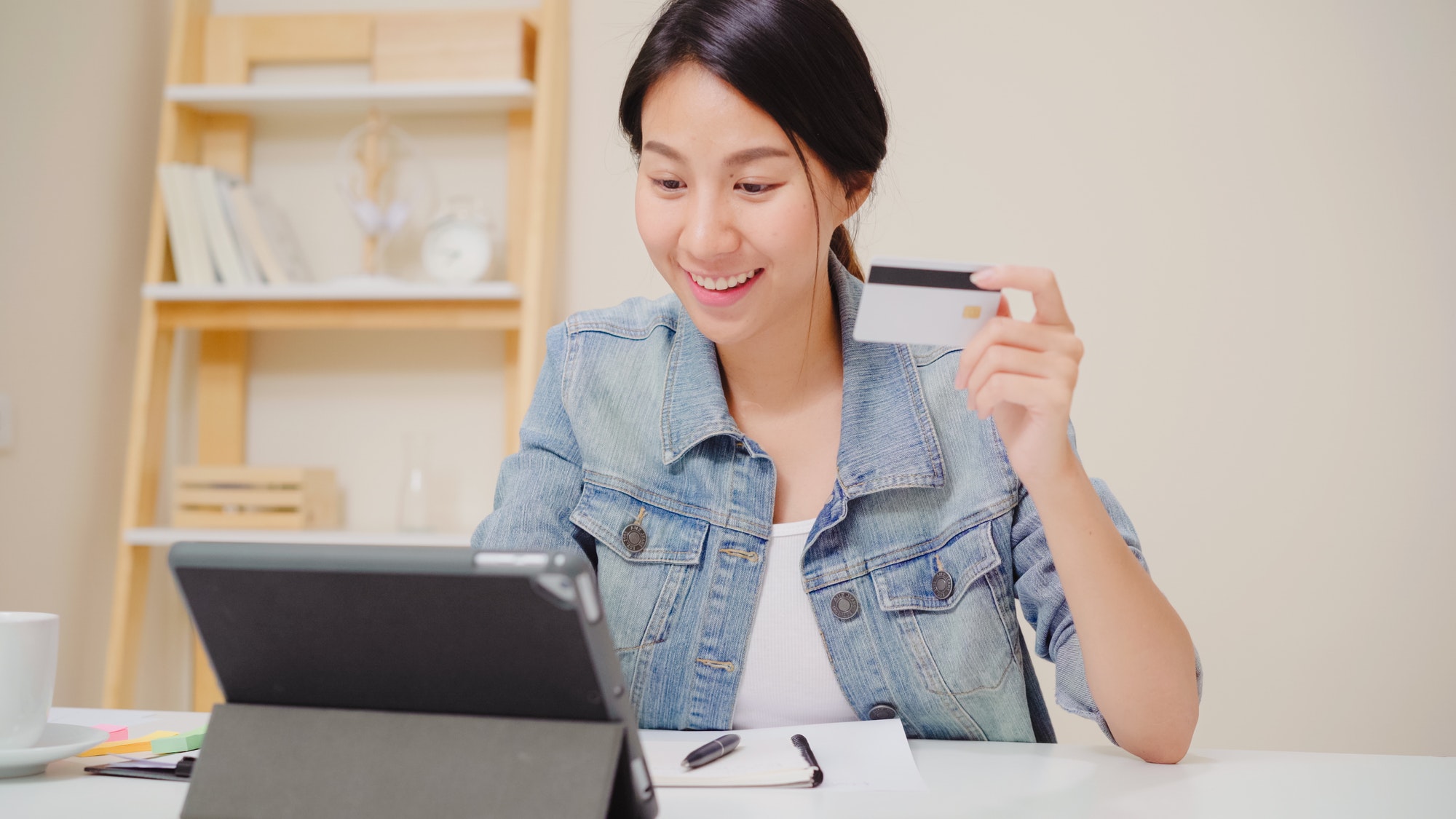 Asian woman using tablet buying online shopping by credit card.