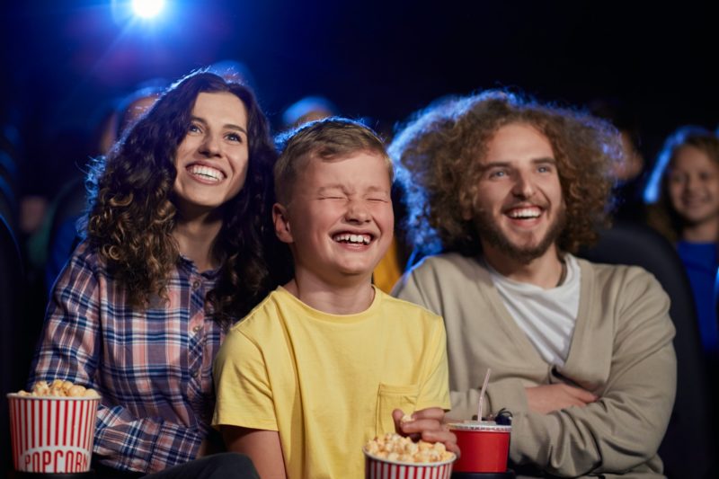 Happy family with son watching cartoon in cinema