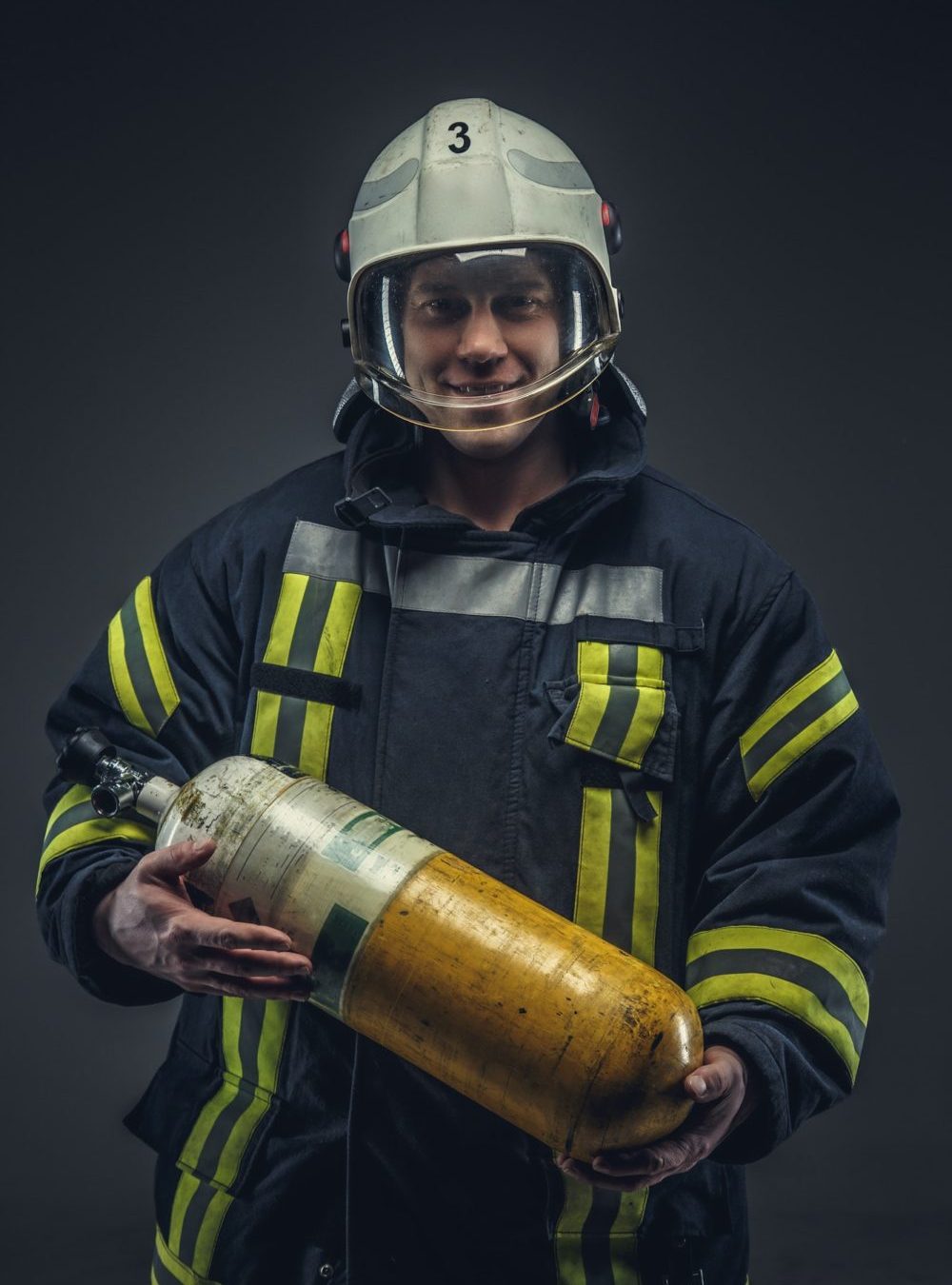 Firefighter rescue holds yellow oxygen tank.