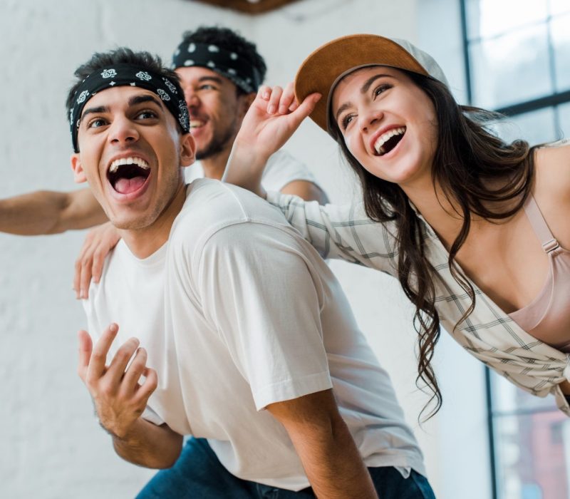 selective focus of cheerful multicultural dancers laughing in dance studio