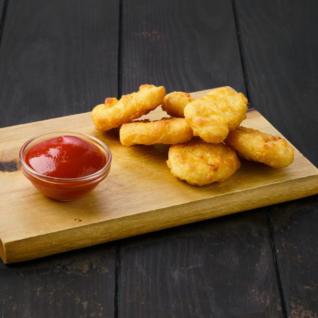 Crispy chicken nuggets in breading served with ketchup