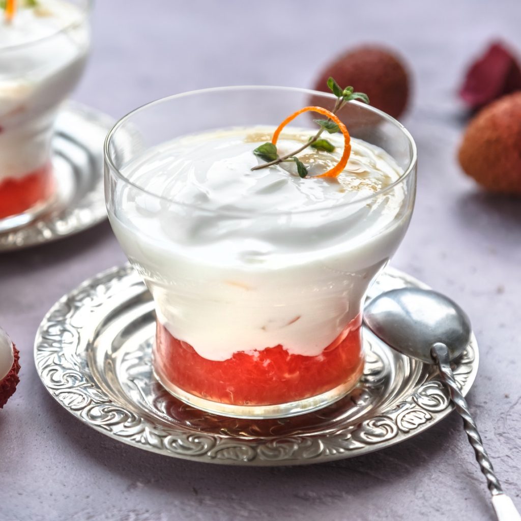 Lychee dessert with grapefruit on pink background