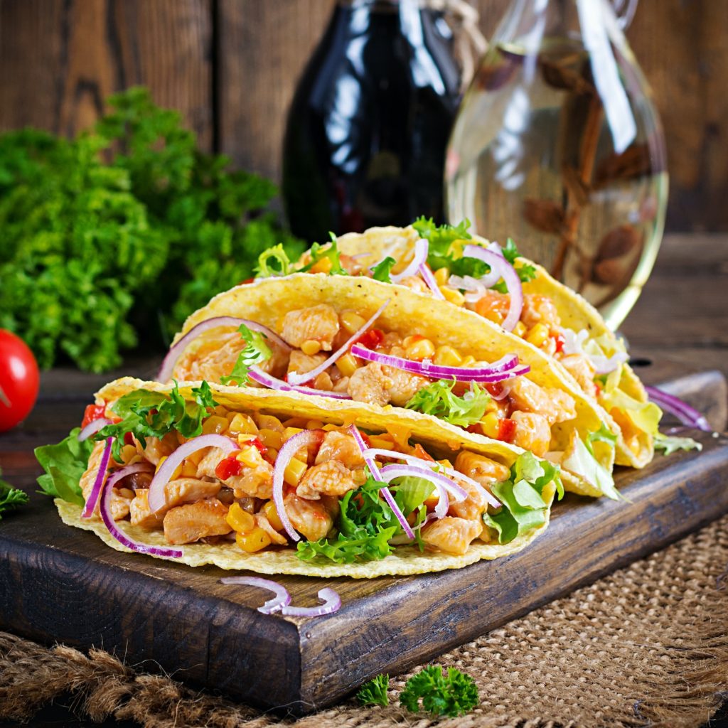 Mexican tacos with chicken meat, vegetables and red onion. Mexican taco.