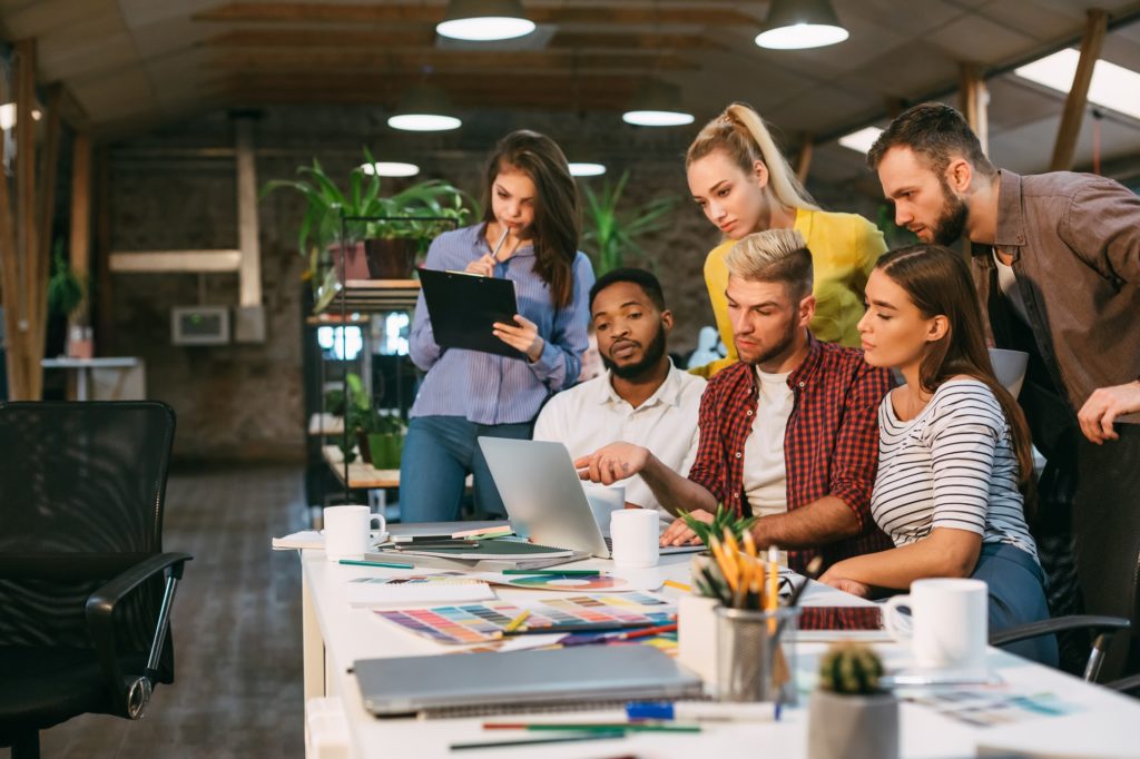 Agency coworkers discussing new project on laptop