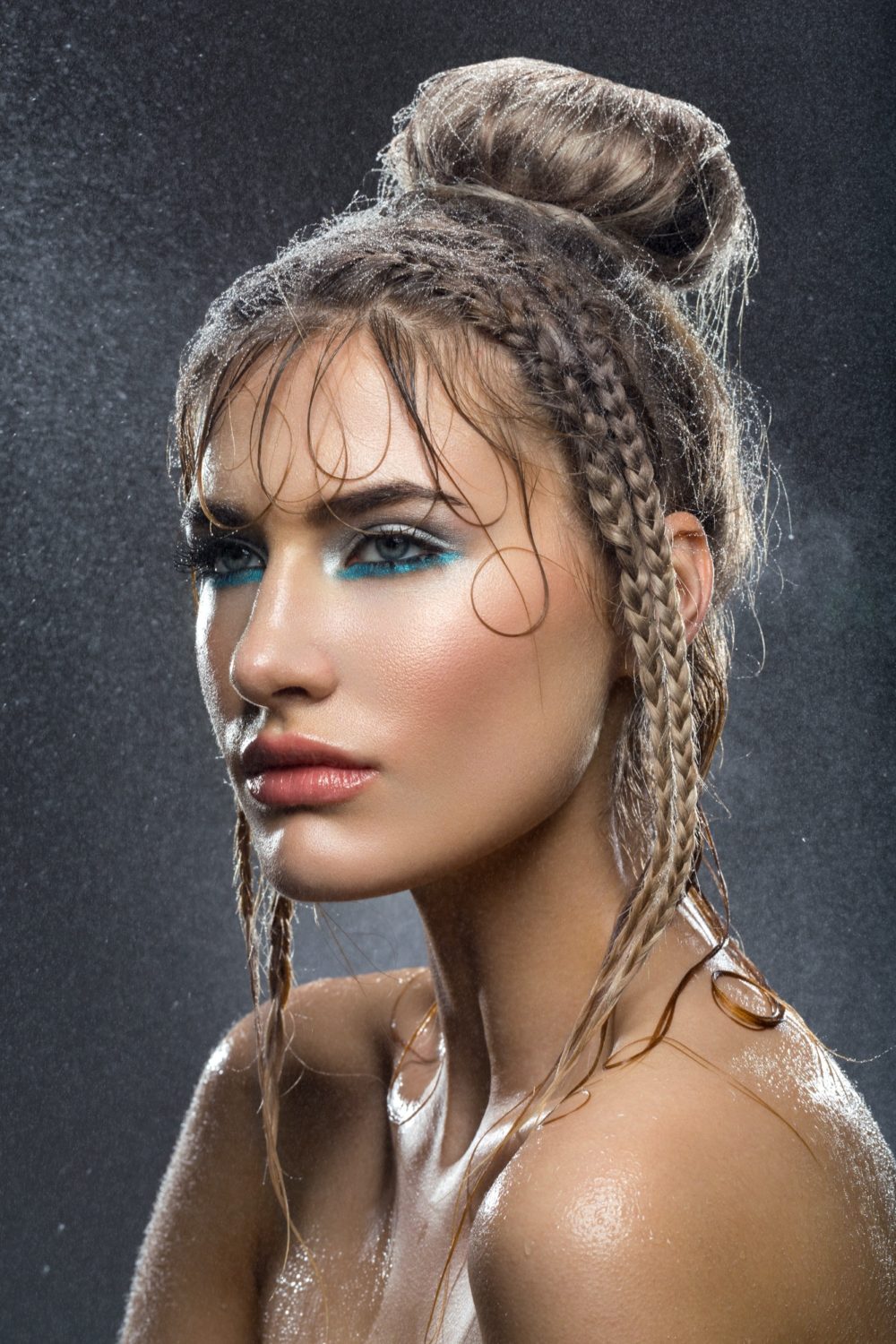 Beautiful girl with blue makeup in water drops