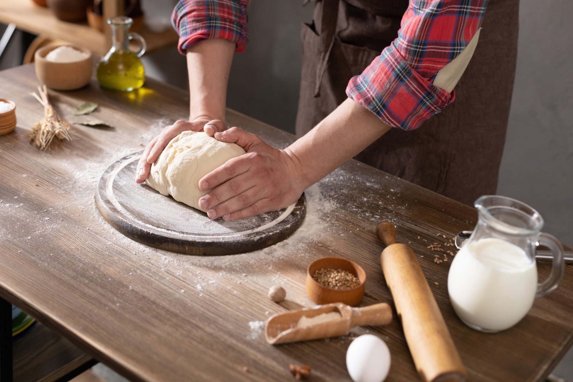 Baker man making dough and bakery ingredients for homemade bread cooking on table. Bakery concept