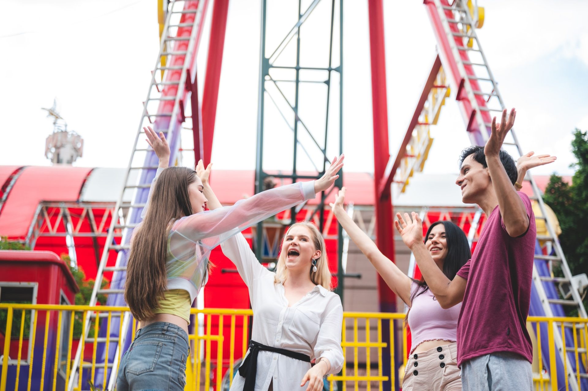 Cheerful diverse people hurting in the theme park, group of friends having fun and relaxing