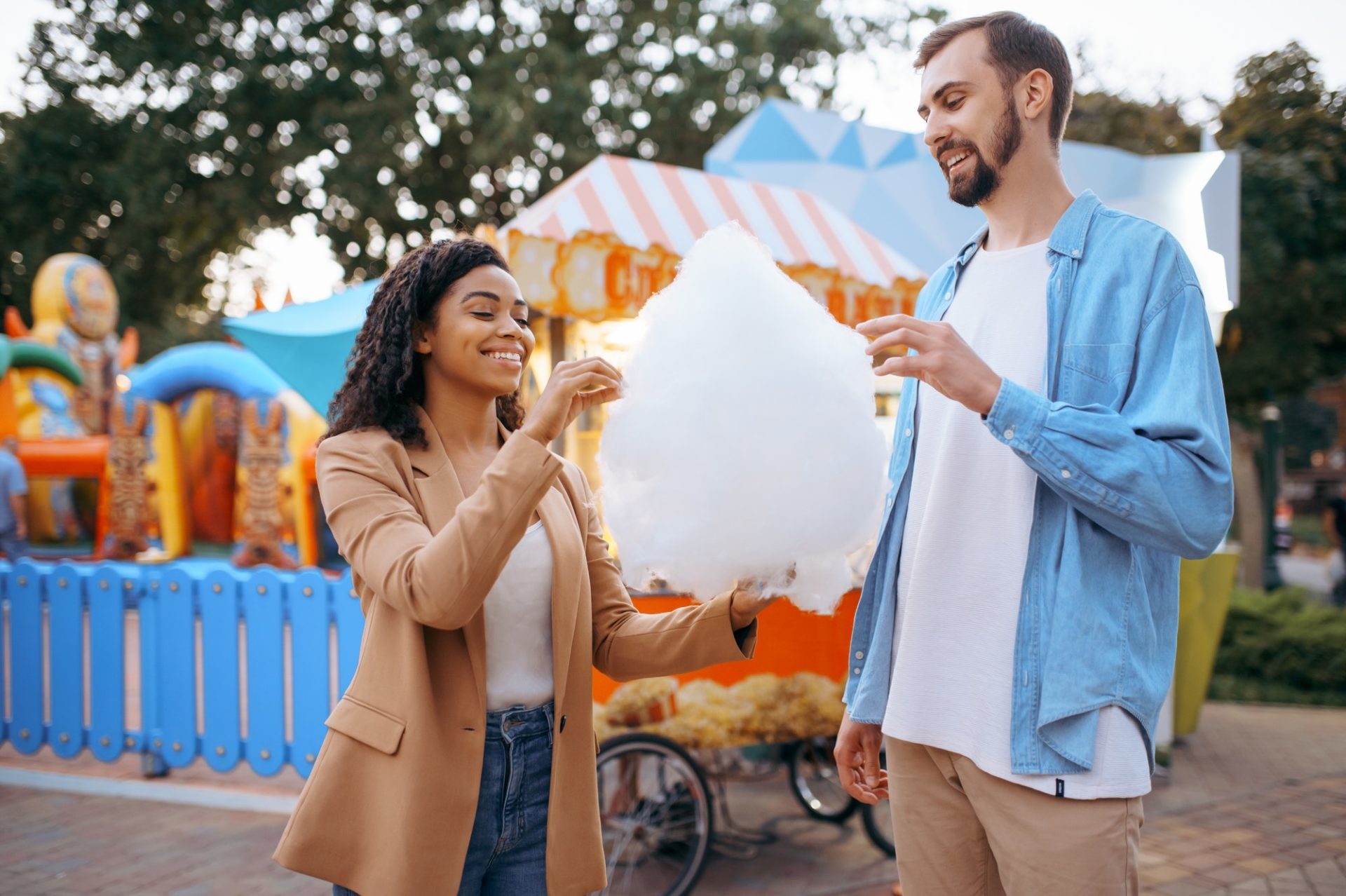 Love couple eating cotton candy in amusement park