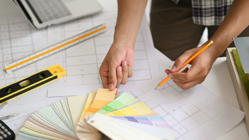 A young man holding a color chart, a young architect chooses a color chart for home design.