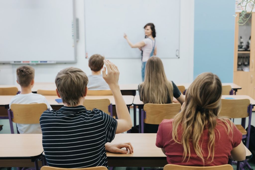 Teacher standing in front of the class room full of teenage students