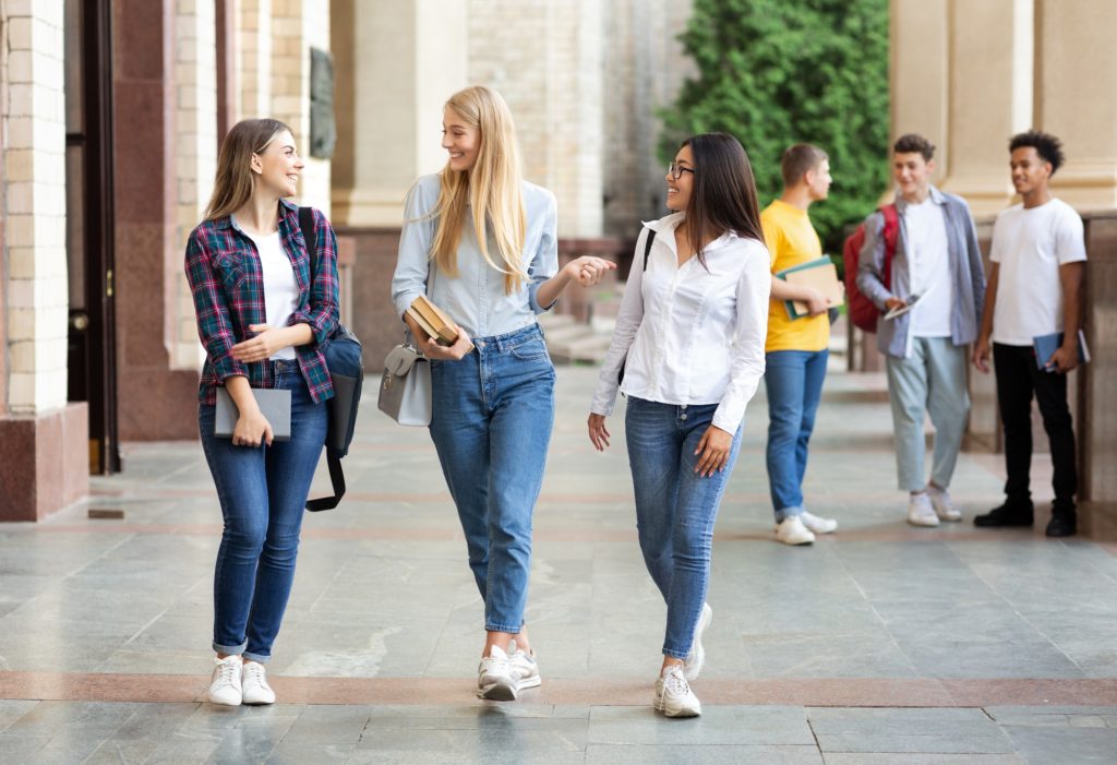 University life. Girls walking after classes outdoors