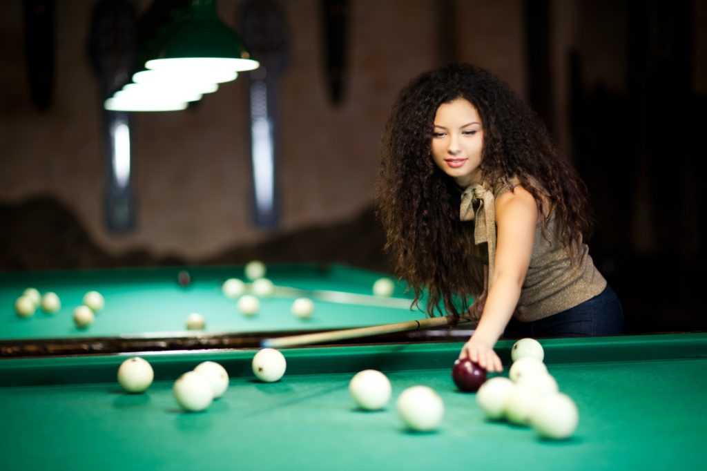 Beautiful girl playing billiards
