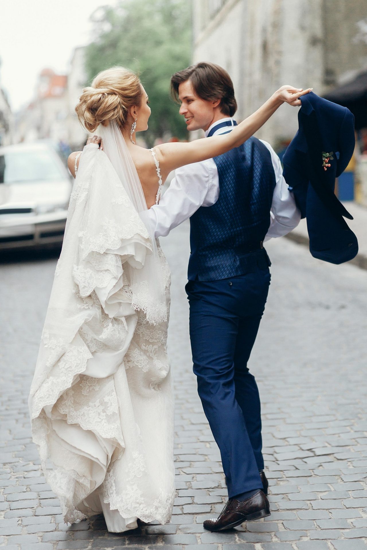 Bride and groom dancing and having fun in city street.