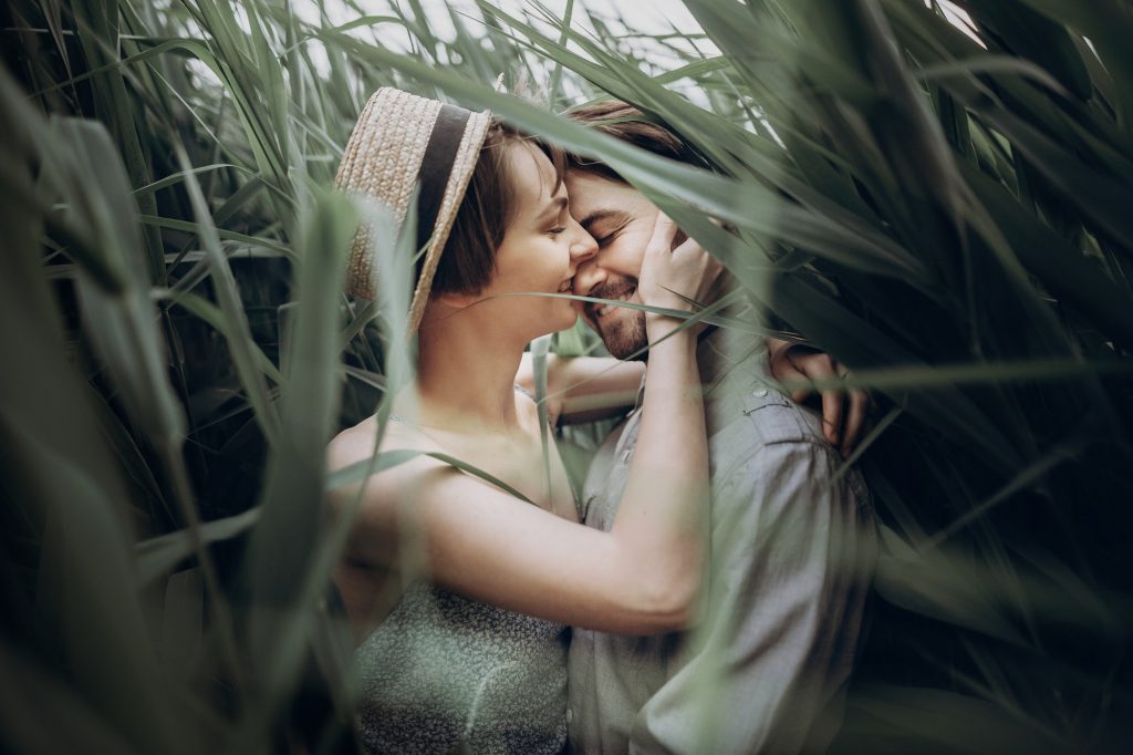 Happy hipster couple embracing at lake in cane