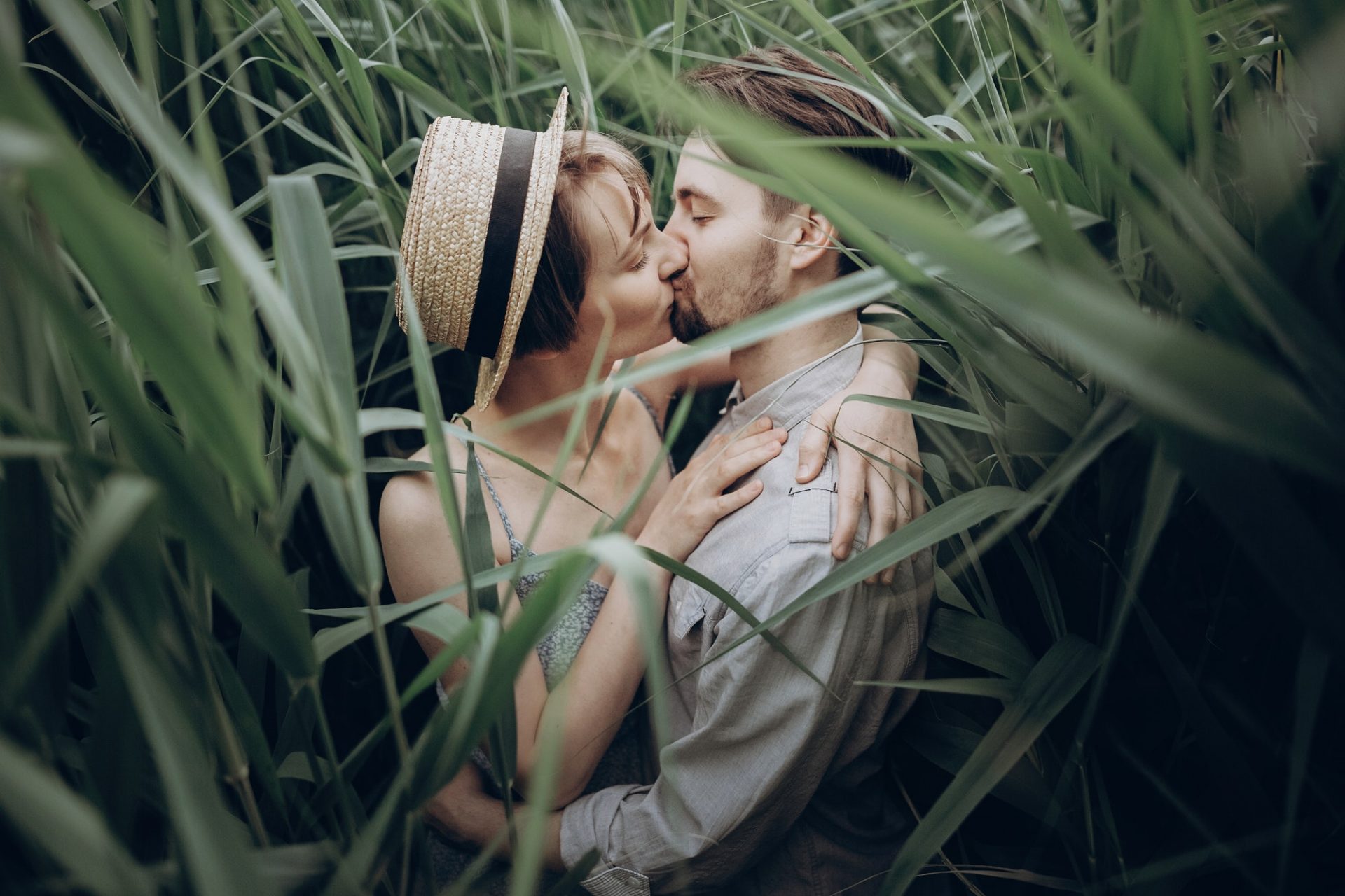 Happy hipster couple embracing at lake in cane