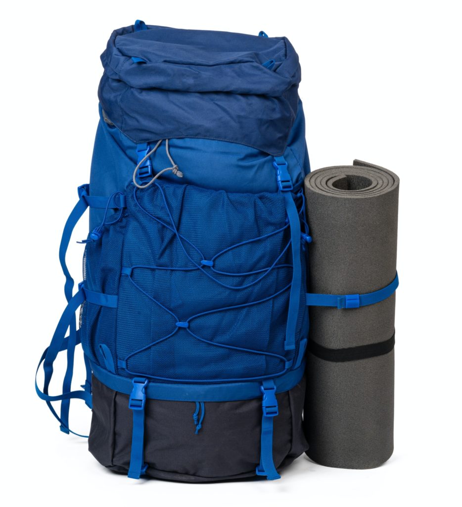 Blue hiking backpack with fitness mat isolated on white