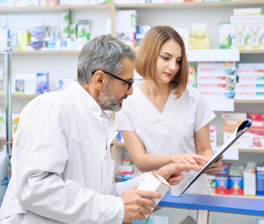 Two pharmacist checking product in folder