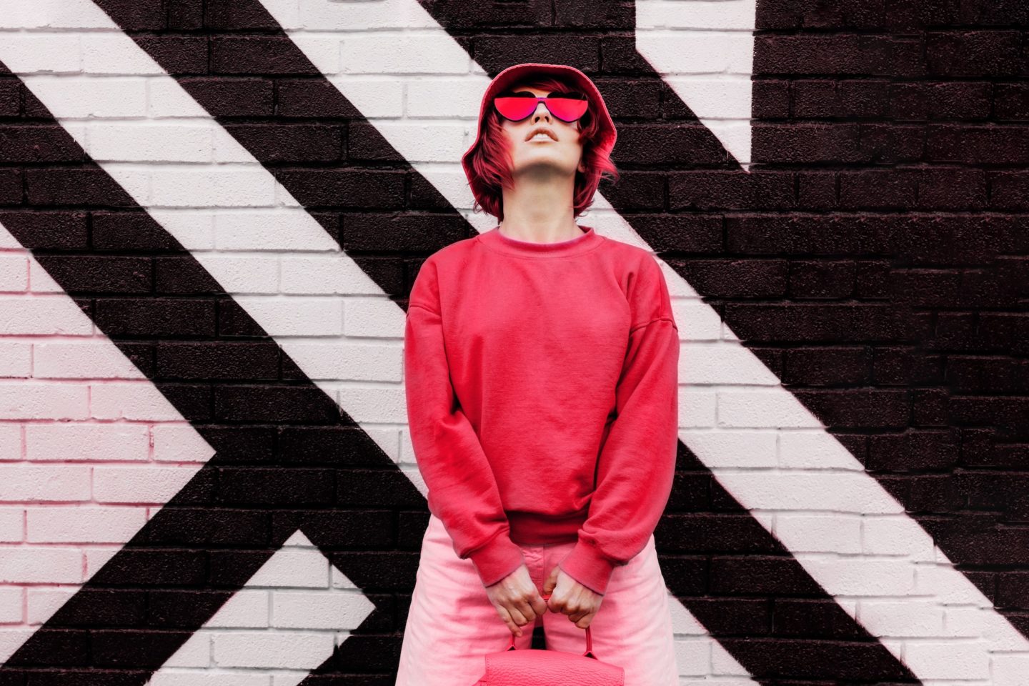 Hipster fashio woman in trendy viva magenta color sweatshirt and sunglasses. Color of 2023 year.