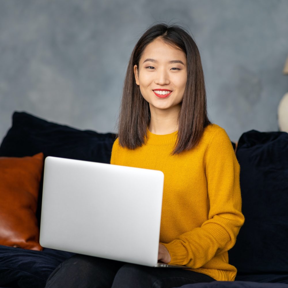 Asian business woman working in laptop on sofa. Japanese businesswoman work at home