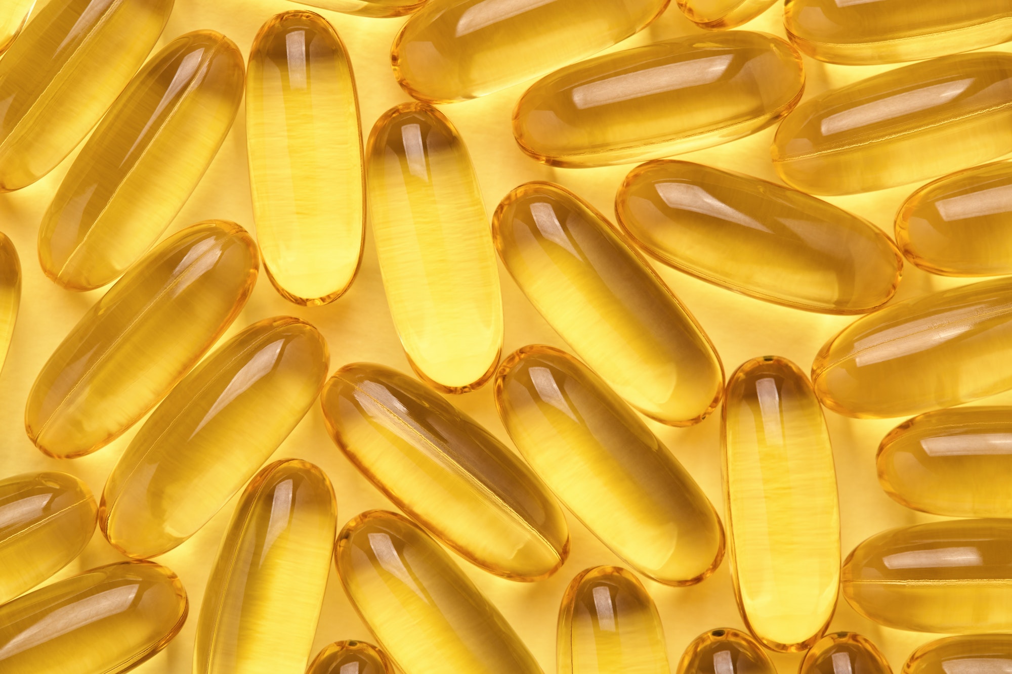 Omega 3 Softgels, Fish Oil Capsules, Yellow Pills Abstract Background.