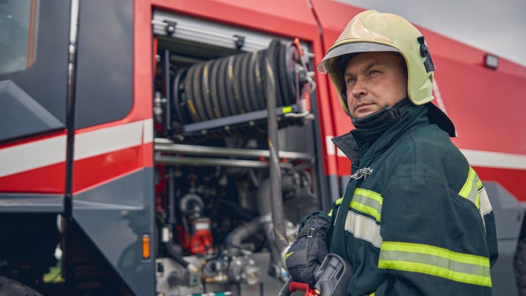 Firefighter is standing near the fire truck