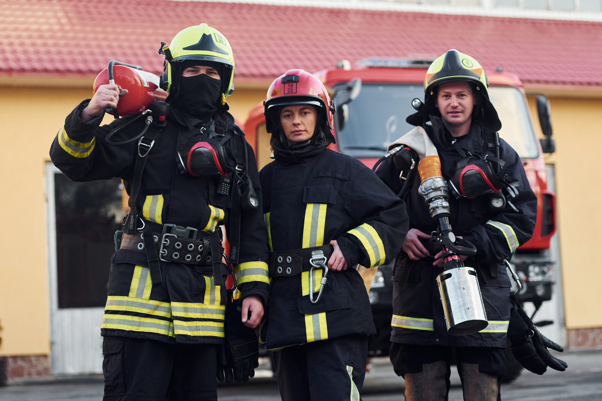 Group of firefighters in protective uniform that outdoors near truck