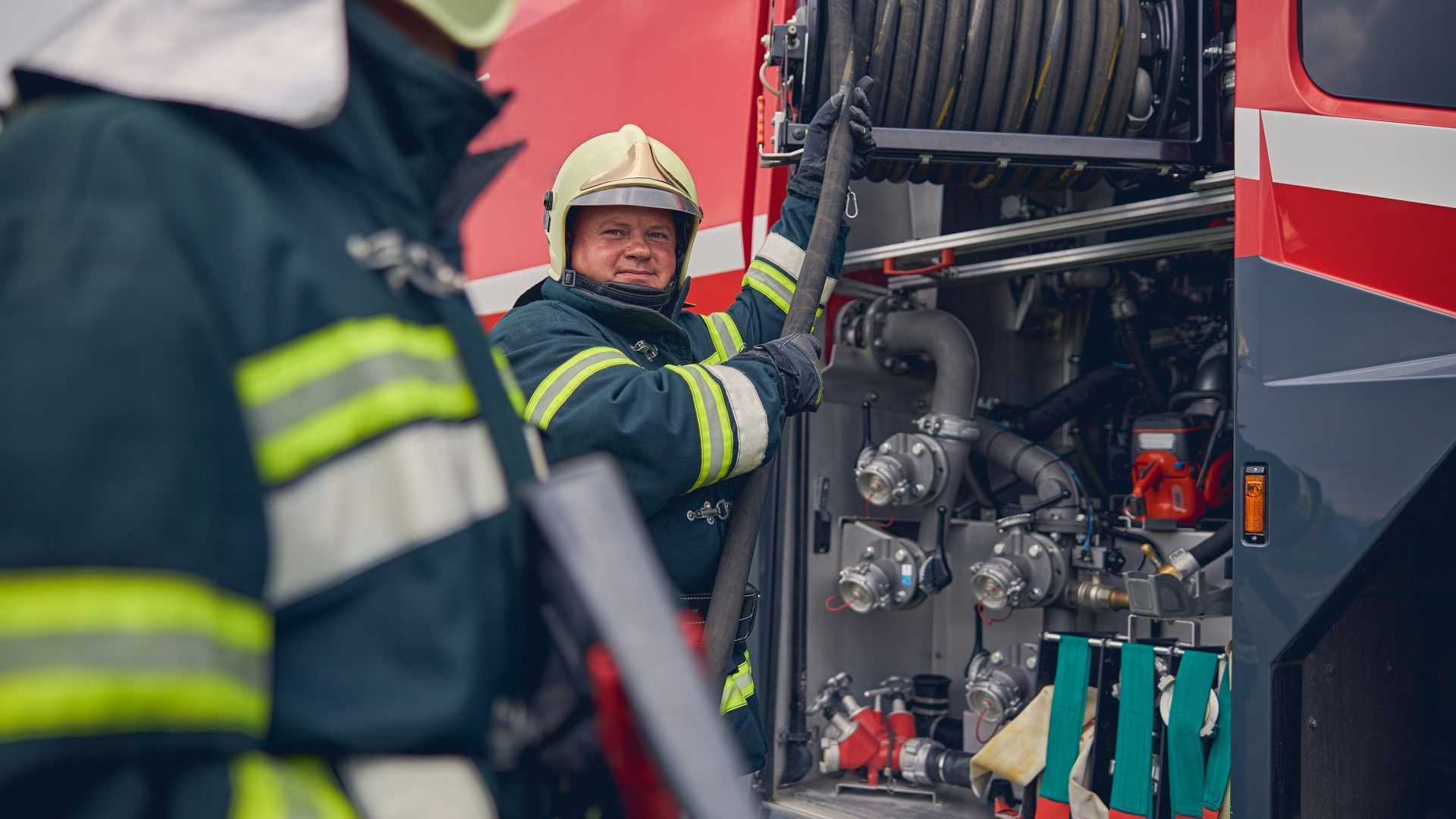 Mature firefighter training work with fire equipment