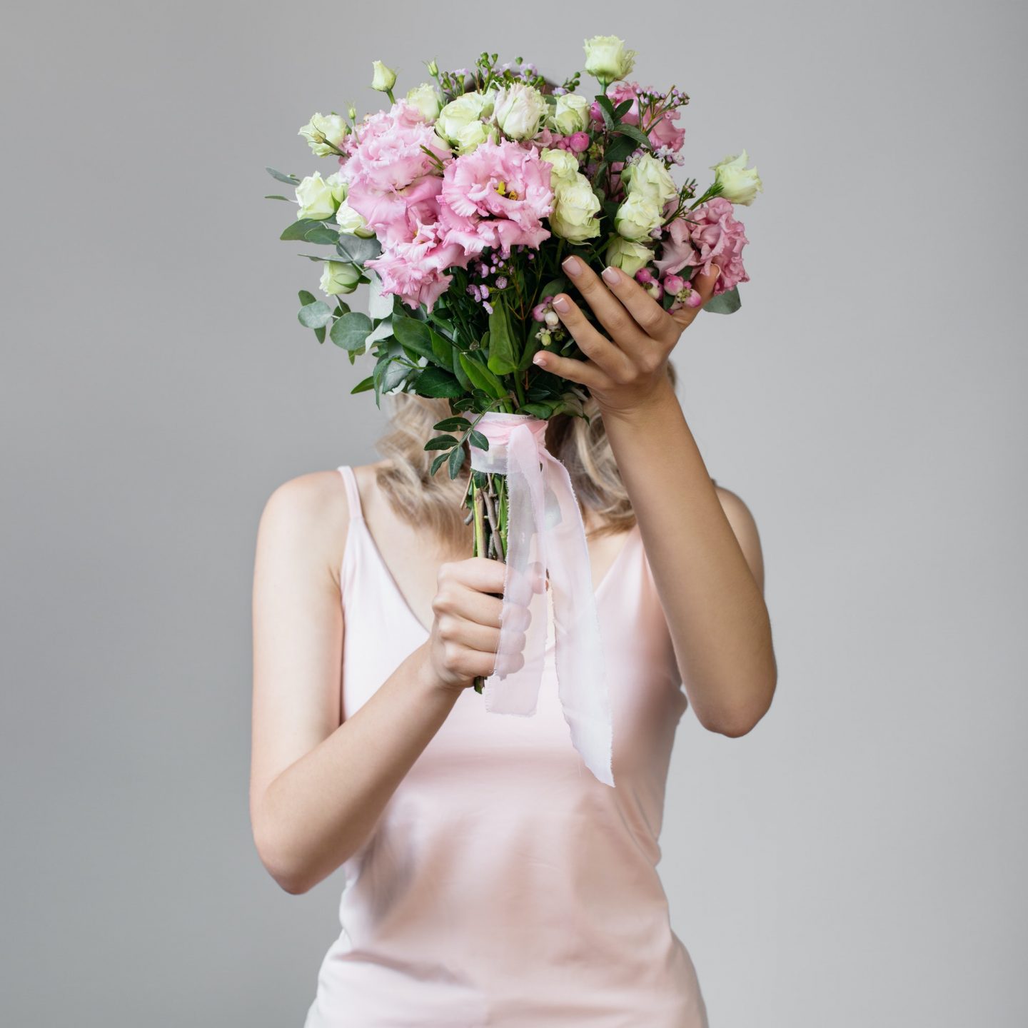 Woman Holding Bouquet In Hands And Hiding Her Face.