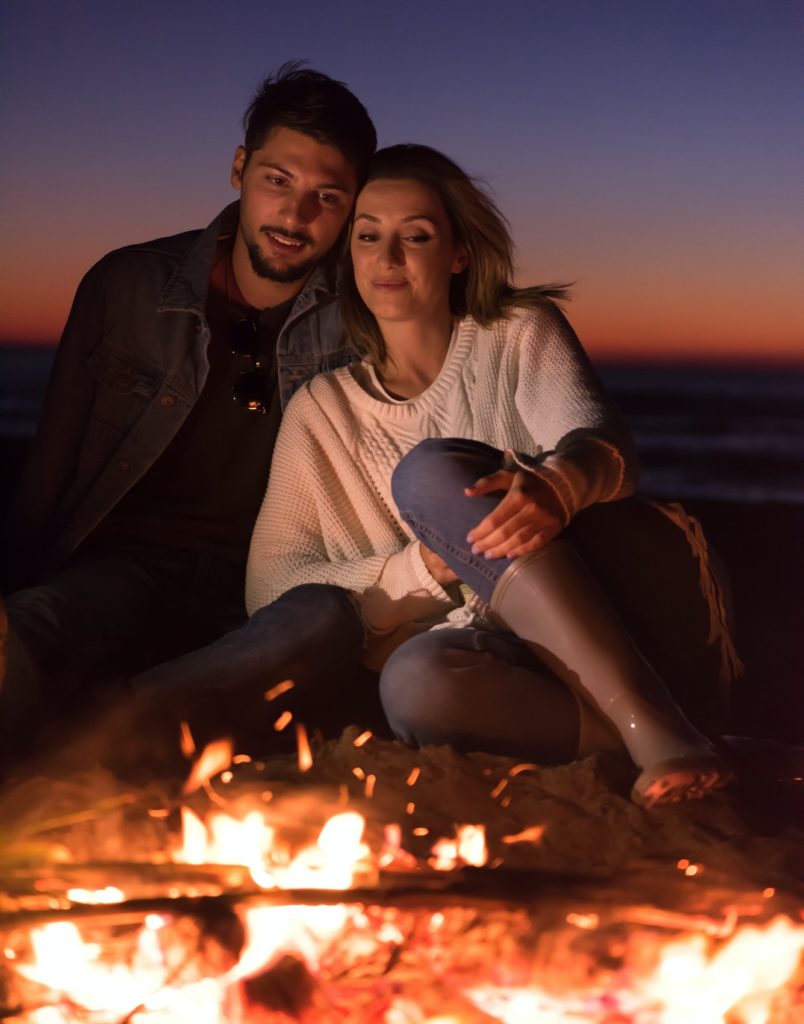 portrait of young Couple enjoying at night on the beach