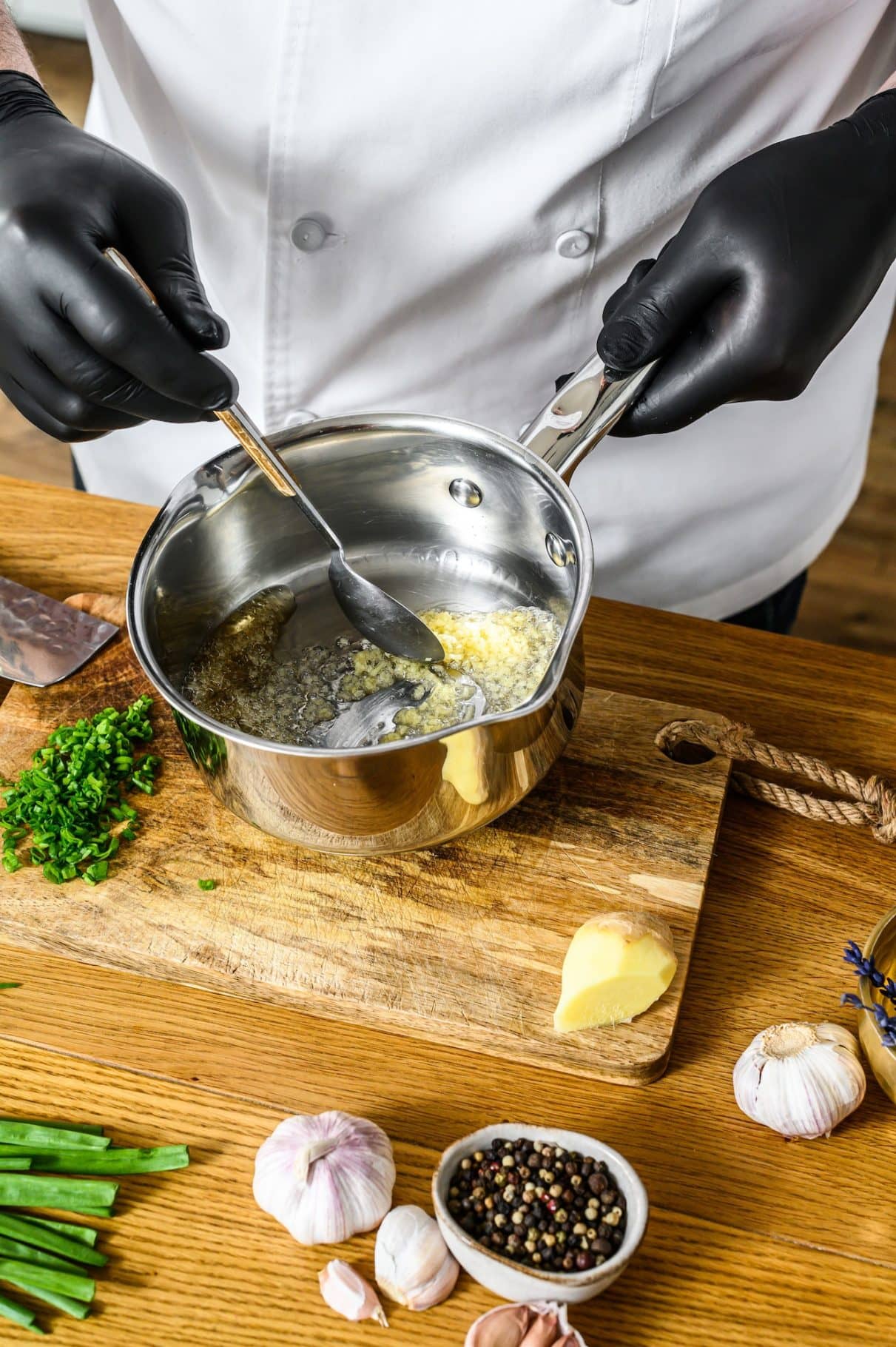 A chef in black gloves prepares stir fry vegetables. Concept of cooking healthy organic food