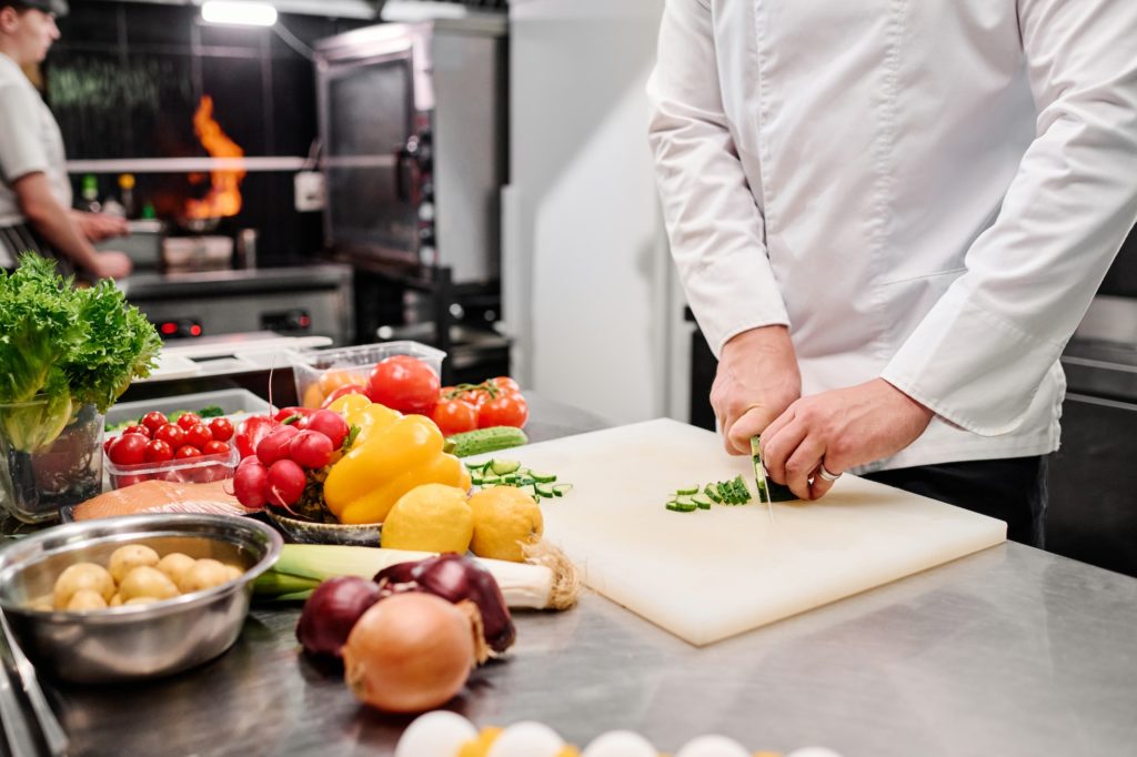 Cook cutting vegetables for salad