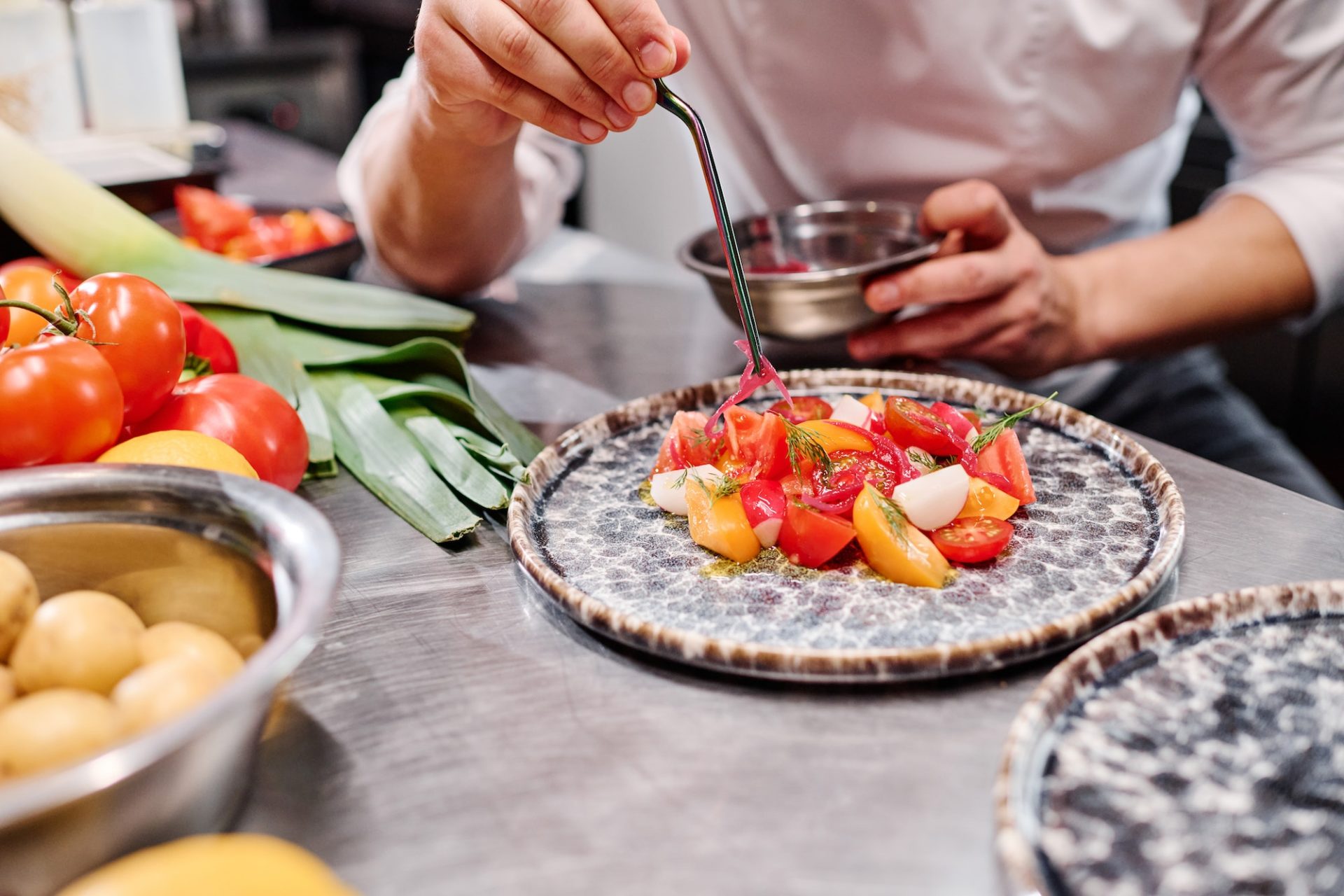 Chef decorating dish with vegetables