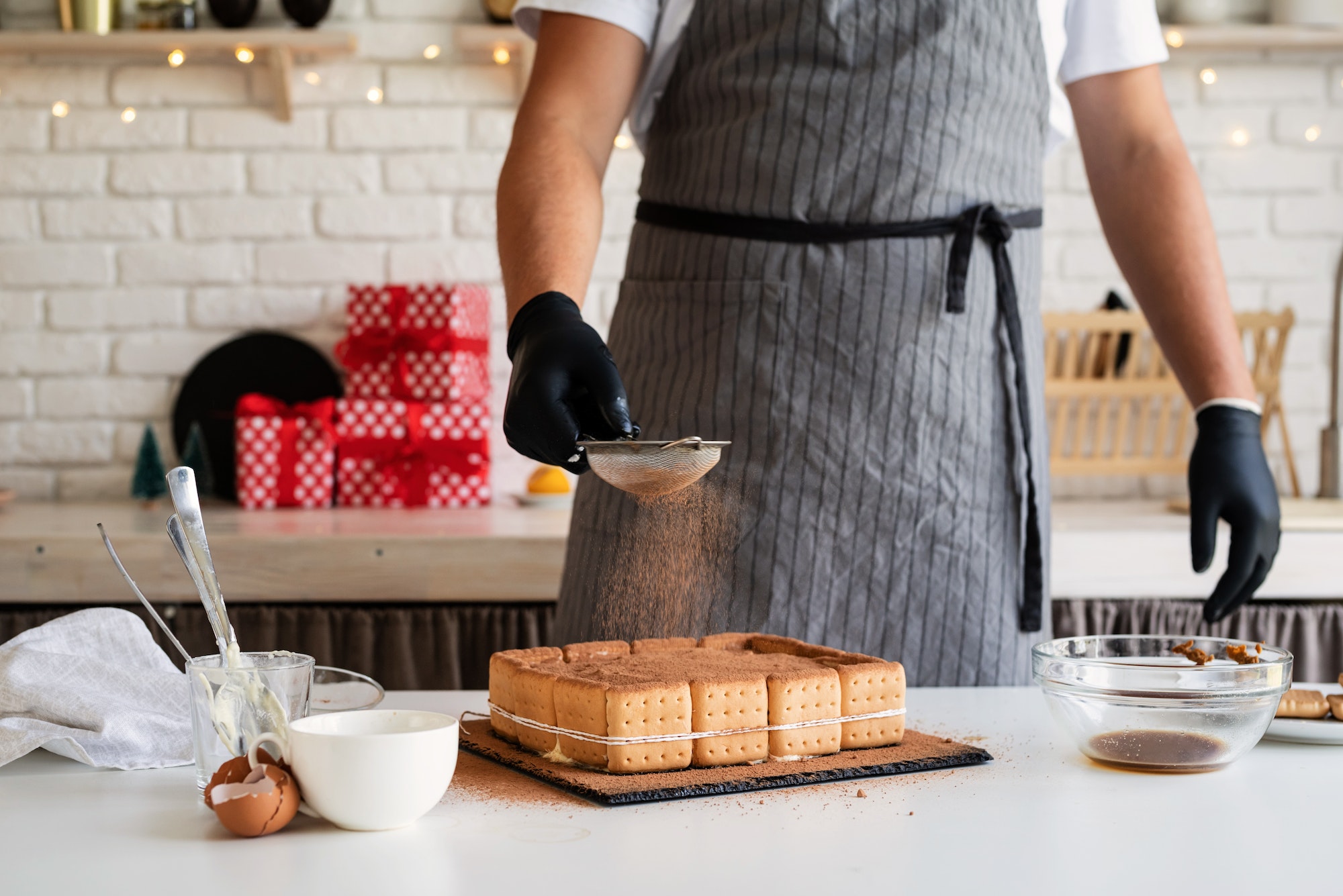 Christmas cooking. Chef cooking dessert in the kitchen pouring cocoa powder on it