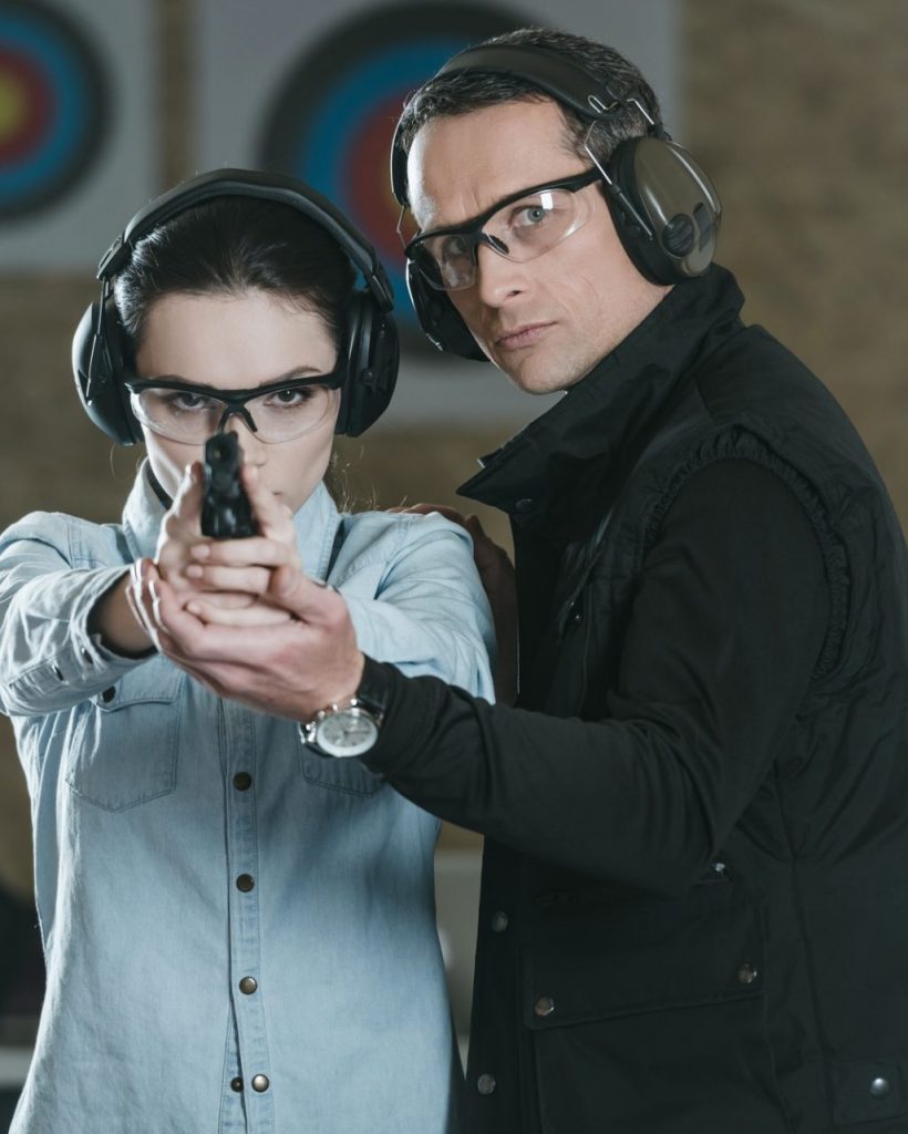 female customer aiming gun at camera in shooting gallery