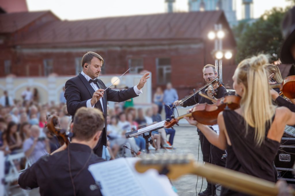 Conductor directing orchestra performance on the street