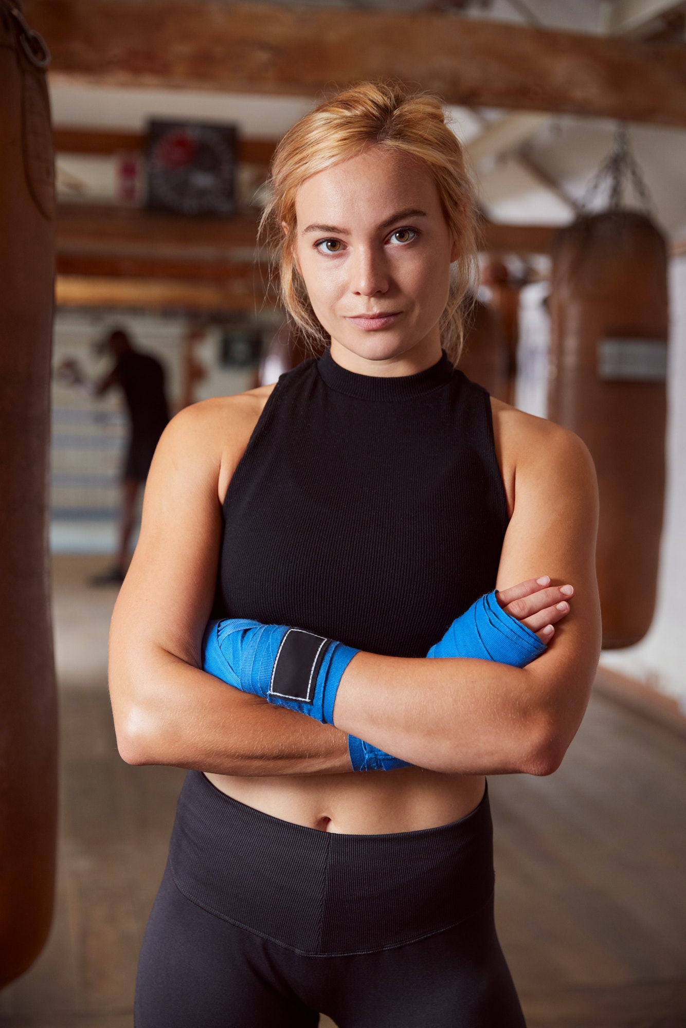 Portrait Of Female Boxer With Protective Wraps On Hands Training In Gym